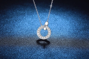 Macro shot of 925 silver necklace with round moissanite pendant on blue background