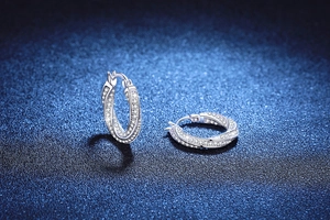 Vue macro des boucles d'oreilles Mobius en argent S925 avec diamants pavés scintillants