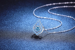 Détail macro du collier goutte d'eau avec moissanite bleue centrale en argent S925