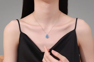 Vue macro du collier en argent S925 avec pendentif moissanite bleue sur un modèle