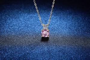 Gros plan d'un pendentif double moissanite rose et incolore sur chaîne dorée