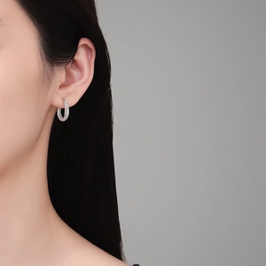 Boucles d'oreilles en argent S925 avec moissanite et double anneau torsadé portées par mannequin