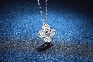 Détail du pendentif trèfle en argent 925 avec moissanite de 1ct sur un fond bleu nuit élégant
