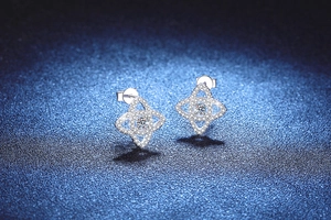 Macro detail of S925 sterling silver four-point star stud earrings with pavé moissanite