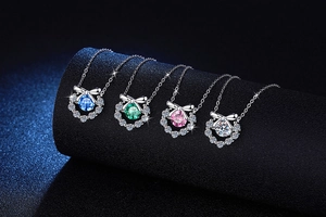 Détail de quatre colliers nœuds en moissanite colorée en bleu vert rose et blanc