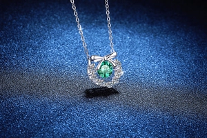 Gros plan détaillé du pendentif nœud serti d'une pierre précieuse moissanite verte