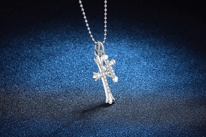 Vue macro d'un pendentif double croix en argent orné de pierres de moissanite brillantes