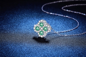 Macro shot of silver clover pendant with green moissanite and micro-pave setting