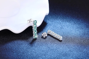 Close-up of S925 sterling silver drop earrings featuring five teal blue moissanite stones