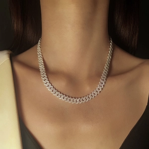 Primer plano de collar de cadena cubana con moissanita brillante en una modelo de moda