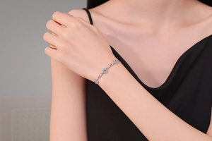 Detailed view of sterling silver flower bracelet with moissanite stones on wrist