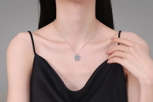 Close-up of S925 silver clover pendant with sparkling moissanite stones on a model