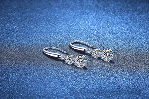 Vue macro de boucles d'oreilles en argent avec moissanite, doubles pierres rondes et crochets