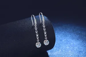 Vue macro de boucles d'oreilles pompons en argent avec détails en zircone cubique ronde