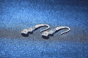 Macro de boucles d'oreilles en argent 925 avec moissanite triangulaire sur fond bleu