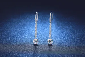 Détail de boucles d'oreilles franges en argent S925 avec pierres moissanites sur fond étoilé