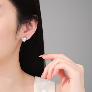 Elegant S925 silver stud earrings featuring high-luster round freshwater pearls and moissanite