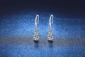 Détail de boucles d'oreilles pendantes en argent avec double pierre moissanite ronde