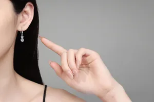 Détail de la boucle d'oreille moissanite en argent portée par le mannequin, style élégant