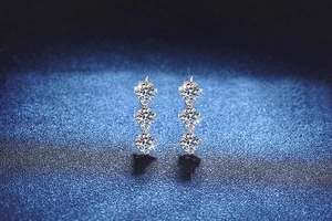 Macro detail of 925 sterling silver drop earrings with three brilliant moissanite stones