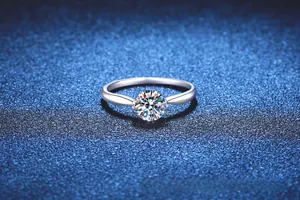Macro view of a 1 carat round moissanite ring with classic four-prong silver setting