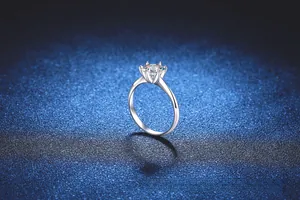 Detailed side view of a six-prong silver engagement ring featuring a sparkling moissanite