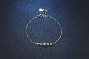 Detailed macro of gold S925 silver bracelet featuring five moissanite stones and heart charm