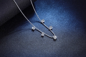 Macro view of S925 silver beaded necklace with five sparkling moissanite stones