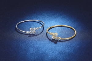 Dettaglio di anelli in moissanite argento e oro su sfondo blu scuro opaco