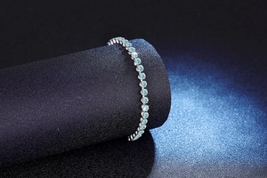 Macro view of sterling silver tennis bracelet with gradient aqua blue moissanite stones