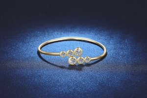 Dettaglio di un bracciale in oro con moissanite e gemme rotonde incastonate