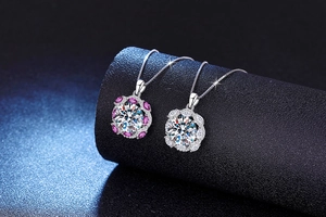 Macro shot of 10 carat moissanite flower pendants with pink accents on box chain