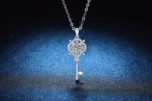 Detailed close-up of a sterling silver key pendant with sparkling moissanite on blue background