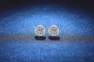 Macro detail of S925 sterling silver halo stud earrings with round moissanite crown setting