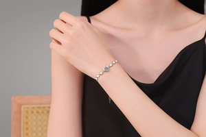 Detailansicht des S925-Silberarmbands mit Herzgliedern und hellblauem Moissanit-Stein