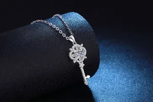 Macro view of S925 sterling silver key pendant with pavé moissanite on black stand