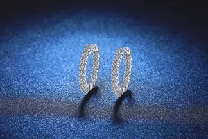 Gros plan détaillé de créoles en argent sterling s925 avec des cristaux blancs étincelants