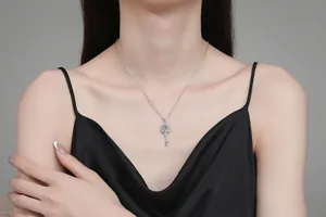 Detailed view of S925 sterling silver key pendant with moissanite on a female model