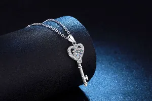 Vue macro d'un pendentif clé en cœur en argent avec moissanite sur support en velours