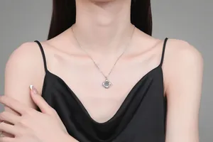 Detail view of a S925 sterling silver heart pendant with a sparkling moissanite on a model