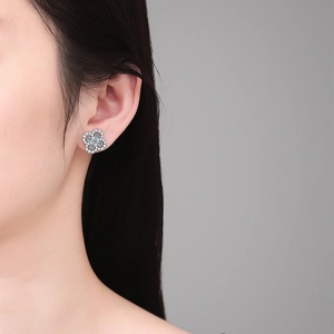 Elegant S925 sterling silver four-leaf clover stud earrings with full diamond pave on a model