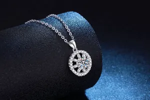 Vue macro du pendentif soleil en argent avec moissanite sur présentoir noir