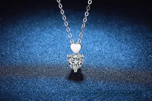 Macro detail of 925 sterling silver necklace featuring double heart pendant with moissanite