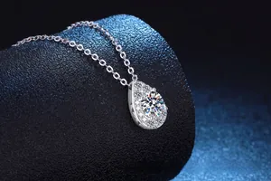 Gros plan d'un pendentif poire en argent 925 avec moissanite de 1ct sur présentoir noir