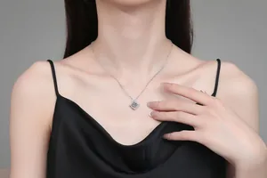 Detail of 925 sterling silver necklace with a brilliant diamond pendant on a model