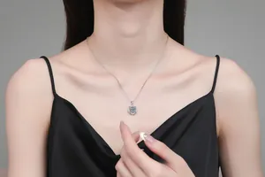 Gros plan du collier en argent sterling S925 avec pendentif trèfle en moissanite sur modèle