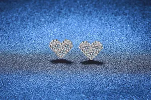 Macro view of S925 sterling silver heart stud earrings featuring sparkling cubic zirconia