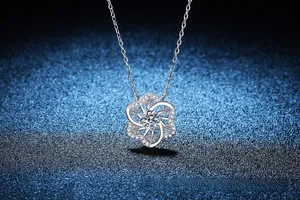 Gros plan du pendentif fleur en argent S925 avec moissanite sur fond bleu étoilé