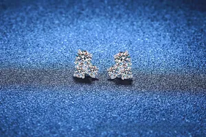 Macro detail of S925 sterling silver cluster earrings with three sparkling round moissanite stones