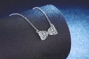 Gros plan du pendentif nœud double cœur en Moissanite 2ct sur chaîne en argent S925